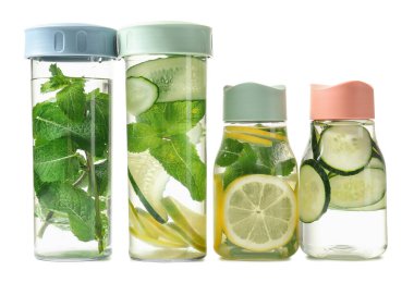 Beyaz arka planda naneli, limonlu ve limonlu temiz su şişeleri