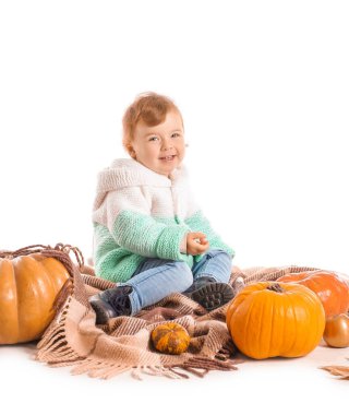 Beyaz arka planda balkabakları olan şirin bir bebek.