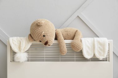 Oyuncak ayı, eldiven ve radyatörde şapka. Isınma mevsimi kavramı