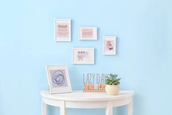 Table near wall with beautiful pictures