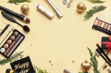 Renk arkaplanında makyaj malzemesi olan yeni yıl kompozisyonu