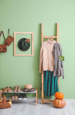 Modern koridorun iç kısımlarında sonbahar kıyafetleriyle dolu raflar.