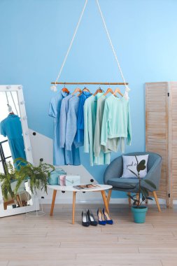 Modern odanın iç kısımlarında sonbahar giysileriyle dolu raflar.