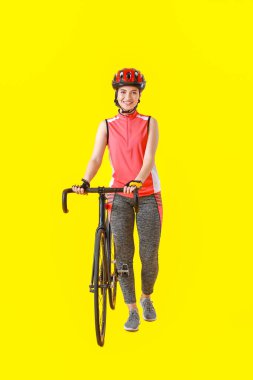 Renkli arka planda bisikleti olan kadın bisikletçi