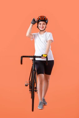 Renkli arka planda bisikleti olan kadın bisikletçi