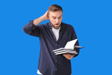 Renk geçmişiyle ilgili kitapları olan şaşırmış genç bir adam.