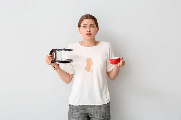 ストレス若いです女性とともにコーヒー汚れで彼女のTシャツ上の白い背景 — ストック写真