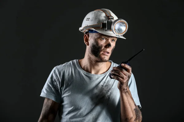 Miner man with two-way radio on dark background