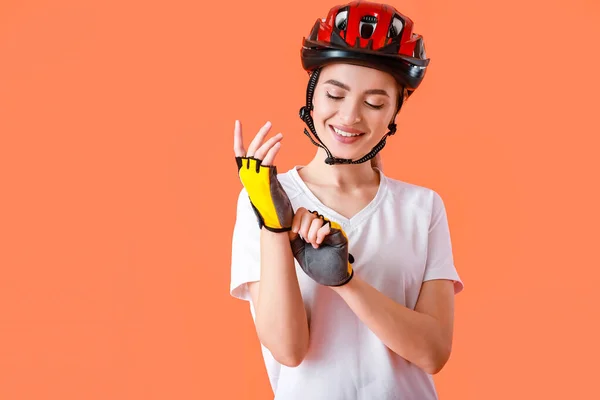 Ciclista Feminino Colocando Luvas Contra Fundo Cor — Fotografia de Stock