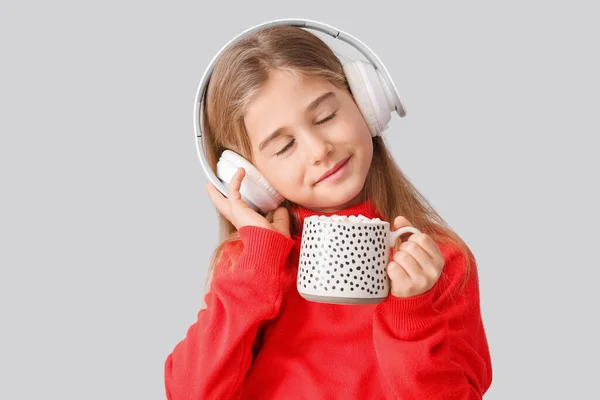 Χαριτωμένο Κοριτσάκι Φλιτζάνι Ζεστή Σοκολάτα Ακούγοντας Μουσική Στο Φως Φόντο — Φωτογραφία Αρχείου