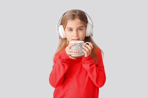 Χαριτωμένο Κοριτσάκι Φλιτζάνι Ζεστή Σοκολάτα Ακούγοντας Μουσική Στο Φως Φόντο — Φωτογραφία Αρχείου