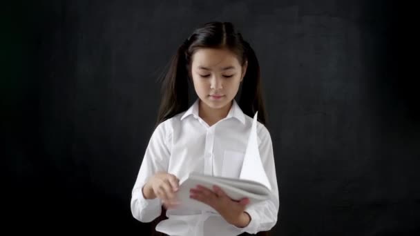 Pequeña Colegiala Con Copybook Sobre Fondo Oscuro — Vídeos de Stock