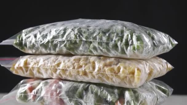 Rotating Plastic Bags Frozen Vegetables Dark Background Closeup — Stock Video