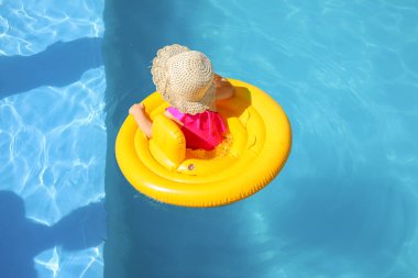 Yüzme havuzunda şişme yüzüğü olan tatlı bir kız.