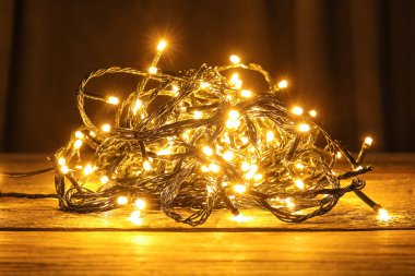 Koyu ahşap masada parlayan Noel ışıkları