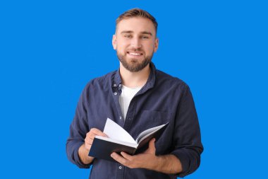 Genç adam renk arkaplanı kitabı okuyor