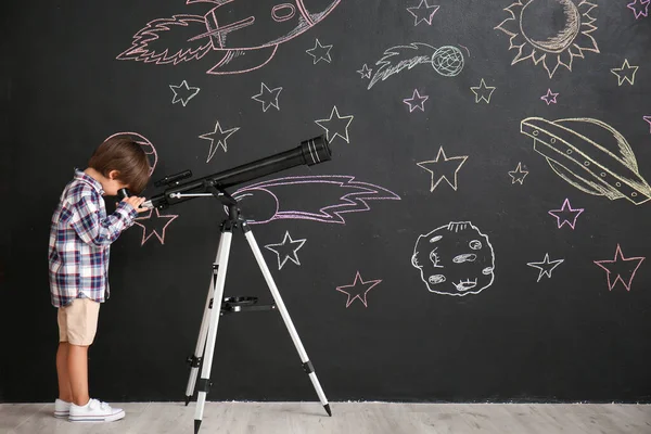 Cute Little Boy Oglądania Teleskopie Czarnej Ścianie Przestrzeni Rysunkowej — Zdjęcie stockowe