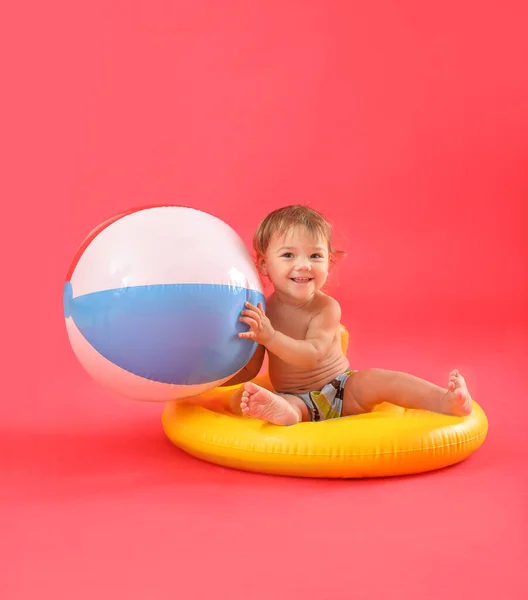 Netter Junge Mit Aufblasbarem Ring Und Strandball Auf Farbigem Hintergrund — Stockfoto