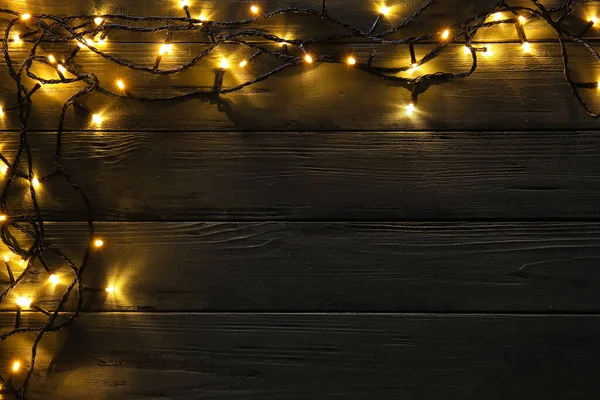 Gloeiende Kerstverlichting Donkere Houten Achtergrond — Stockfoto