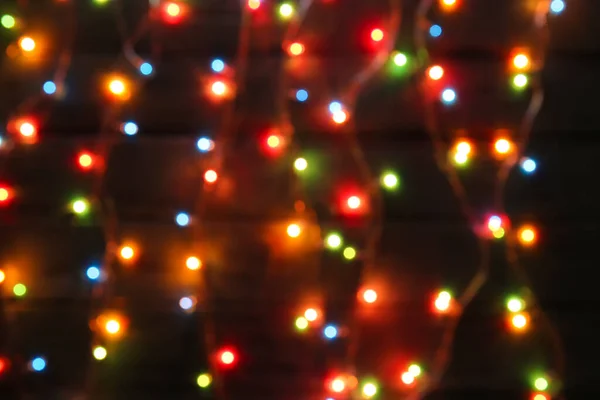 Leuchtende Weihnachtsbeleuchtung Auf Dunklem Holzhintergrund Verschwommene Sicht — Stockfoto
