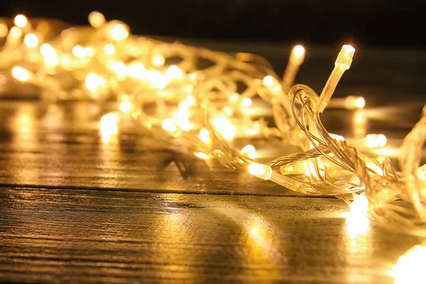 Glowing Christmas Lights Dark Wooden Table Closeup — Stock Photo, Image