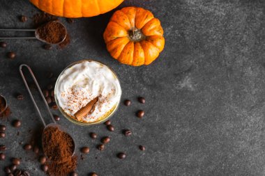 Koyu arkaplanda bir bardak kabak kapuçino.