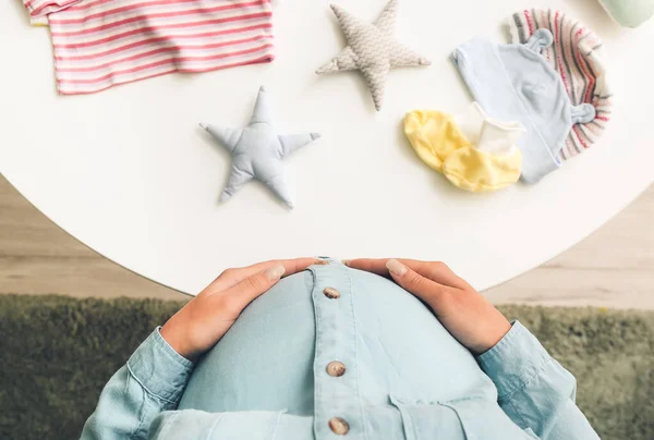 Beautiful Pregnant Woman Table Baby Clothes Top View — Stock Photo, Image