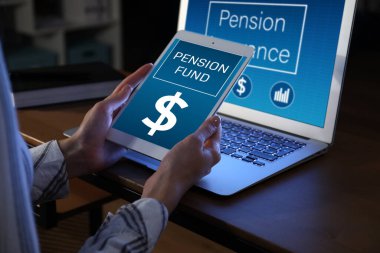 Tablet bilgisayarı olan bir kadın evde emeklilik fonunun çevrimiçi hizmetini kullanıyor