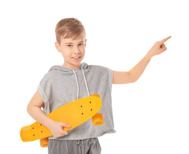 Kaykaylı yakışıklı çocuk beyaz arka planda bir şeye bakıyor.