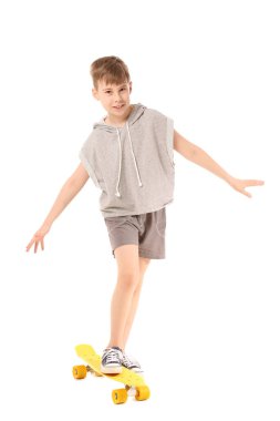 Beyaz arka planda kaykayı olan tatlı bir çocuk.