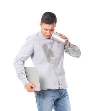 Gömleğinde lekeler olan genç bir adam dizüstü bilgisayarını beyaz arka planda tutuyor.