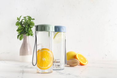 Işık masasının üzerinde limonlu su şişeleri