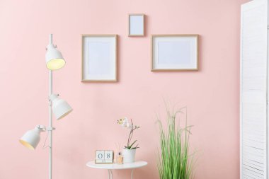 Renk duvarında boş fotoğraf çerçeveleri olan modern odanın içi
