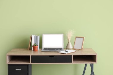 Renk duvarının yanında modern dizüstü bilgisayarı olan rahat bir iş yeri