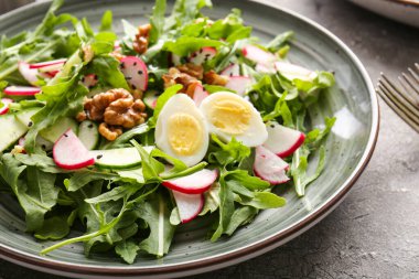 Koyu arkaplanda lezzetli roka salatası.