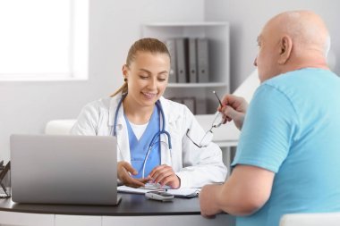 Kıdemli diyabetik adam klinikteki doktoru ziyaret ediyor.