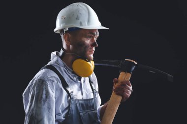 Karanlık arka planda baltası olan madenci.