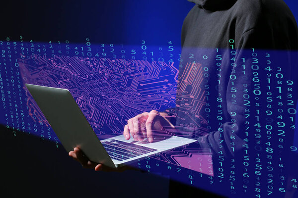 Профессиональный хакер с ноутбуком на темном фоне