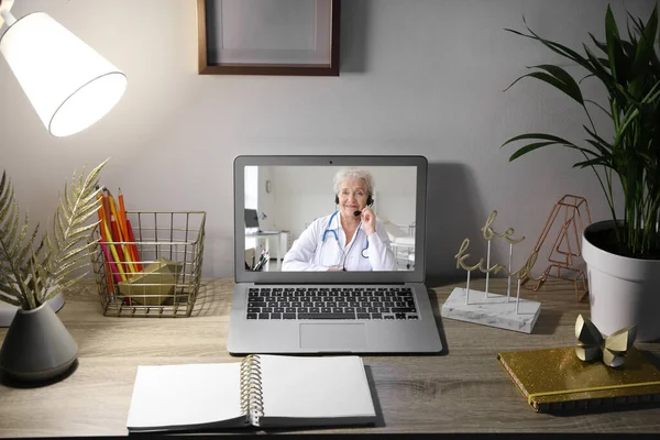 Laptop with female doctor on screen in room. Concept of telemedicine