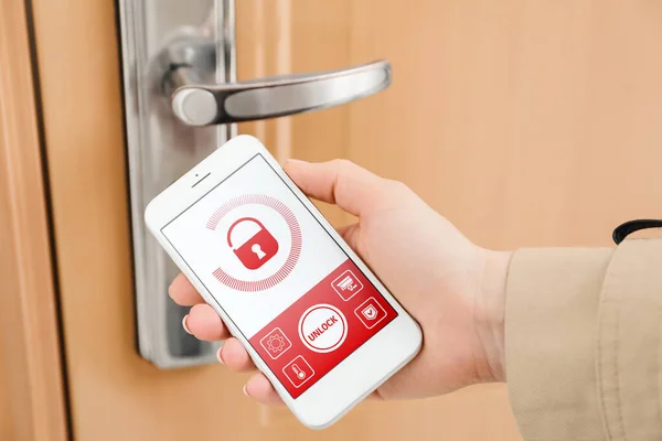 Woman using mobile phone to open door