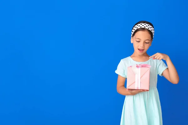 Überrascht Kleines Mädchen Mit Geschenk Auf Farbigem Hintergrund — Stockfoto