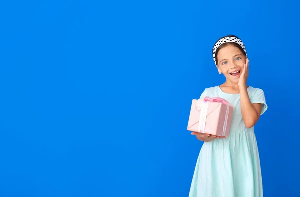 Glückliches Kleines Mädchen Mit Geschenk Auf Farbigem Hintergrund — Stockfoto