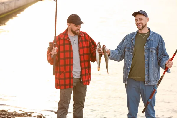 Nehirde balık tutan mutlu genç adamlar