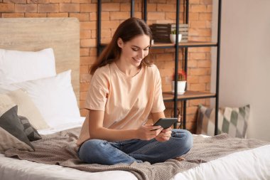 Evde e-kitap okuyan güzel genç bir kadın.