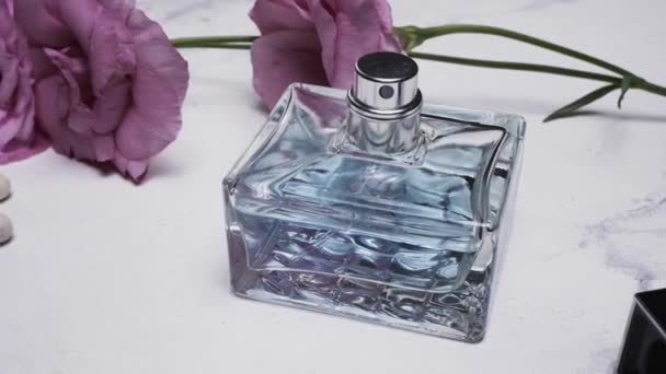 浅色背景的香水瓶和美丽的花朵 — 图库视频影像