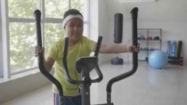 Kilolu Asyalı çocuk beden eğitimi yapıyor.