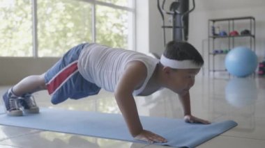 Kilolu Asyalı çocuk beden eğitimi yapıyor.