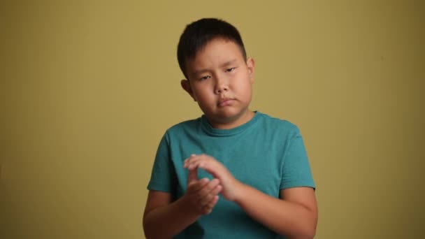 Sorglig Övervikt Asiatisk Pojke Klappar Händer Färg Bakgrund — Stockvideo