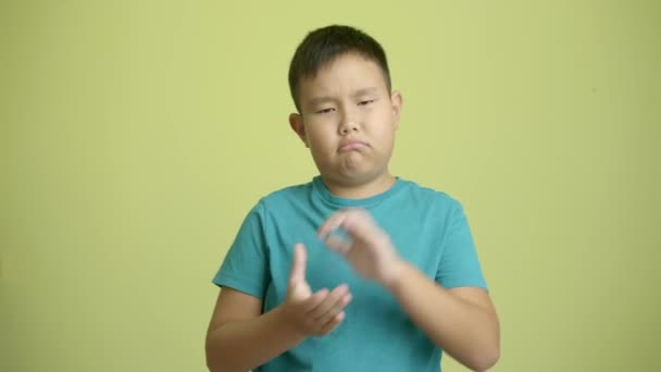 悲喜交加的亚洲男孩拍着彩色背景的手 — 图库视频影像