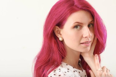 Beyaz arka planda parlak, sıra dışı saçları olan güzel bir genç kadın.